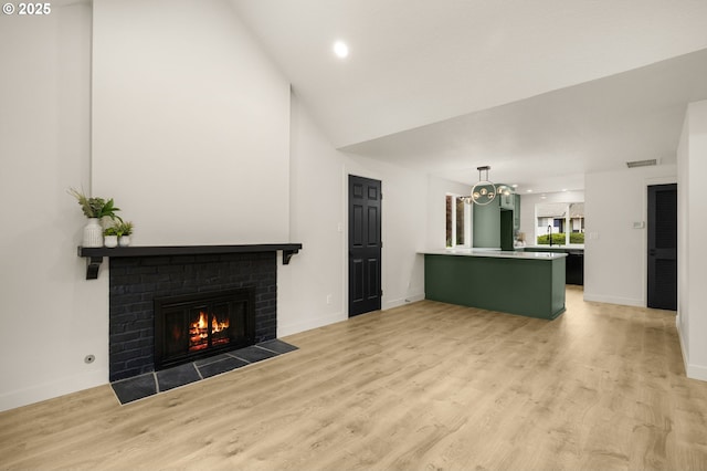18090 NW Avalon Dr, Portland, OR 97229 - unfurnished living room featuring a fireplace, light wood-type flooring, recessed lighting, high vaulted ceiling, and a chandelier