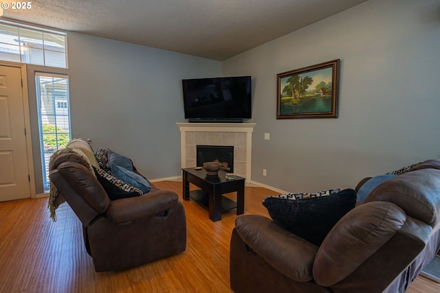 2872 Bluff Ave, Salem, OR 97302 - living room with a tiled fireplace, light wood-style flooring, and baseboards