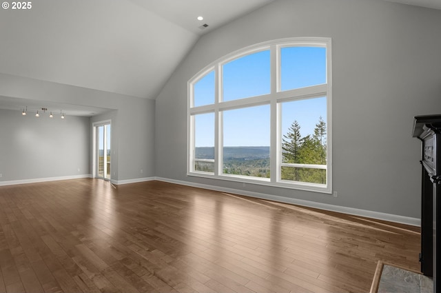 unfurnished living room with high vaulted ceiling, visible vents, baseboards, and wood finished floors