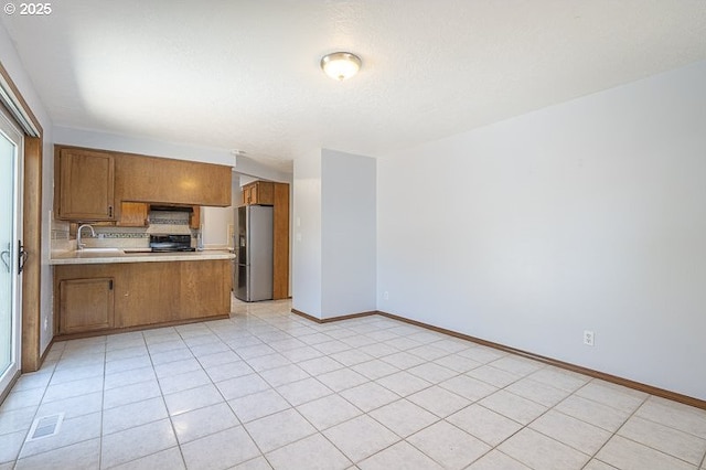 5270 Faircrest Ct SE, Salem, OR 97306 - kitchen featuring a peninsula, brown cabinets, a sink, stainless steel fridge with ice dispenser, and light countertops