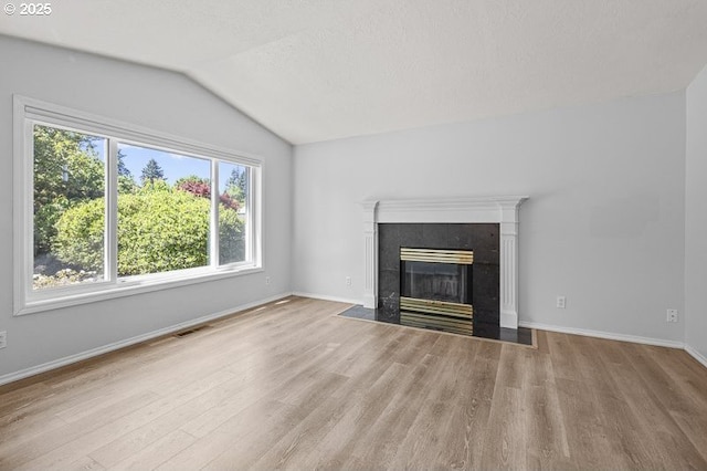 5270 Faircrest Ct SE, Salem, OR 97306 - unfurnished living room featuring a premium fireplace, vaulted ceiling, visible vents, and wood finished floors
