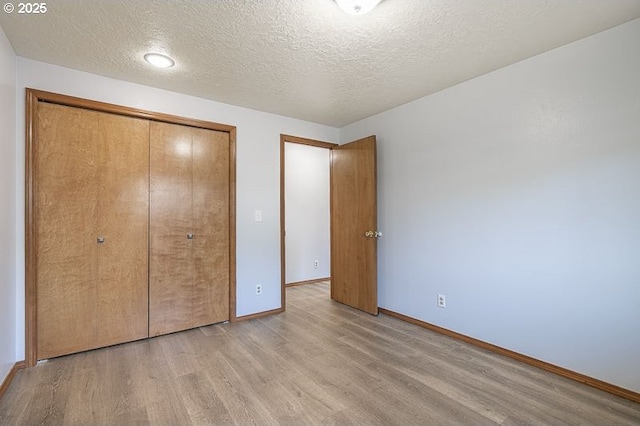 5270 Faircrest Ct SE, Salem, OR 97306 - unfurnished bedroom featuring a textured ceiling, baseboards, a closet, and light wood-style floors