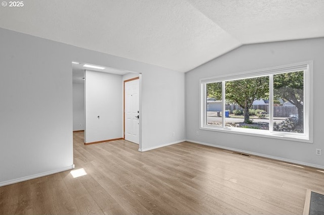 5270 Faircrest Ct SE, Salem, OR 97306 - unfurnished living room featuring a textured ceiling, baseboards, visible vents, vaulted ceiling, and wood finished floors