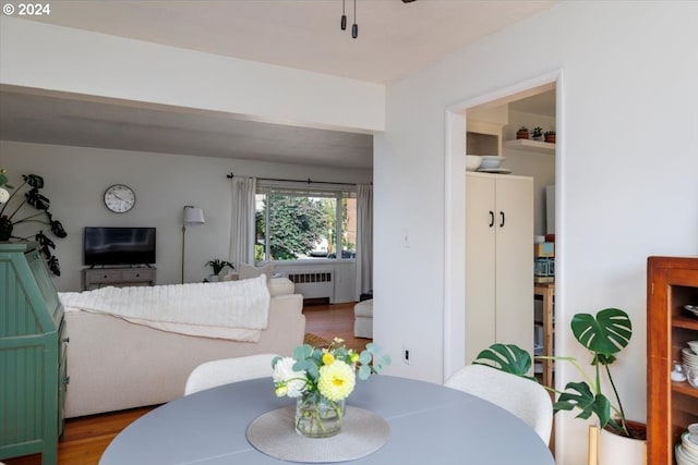 dining room featuring dark wood-type flooring, radiator heating unit, and ceiling fan