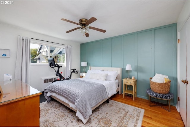 bedroom featuring radiator, ceiling fan, and light hardwood / wood-style flooring