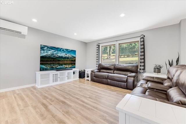 living room with a wall mounted AC and light hardwood / wood-style flooring