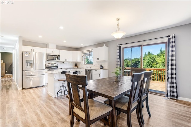 dining room with light hardwood / wood-style floors, a healthy amount of sunlight, and sink