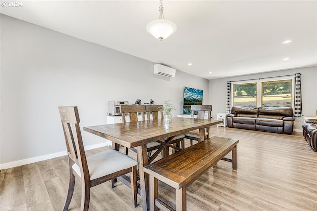 dining area with a wall mounted AC and light wood-type flooring