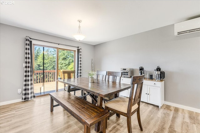 dining room with a wall mounted air conditioner and light wood-type flooring