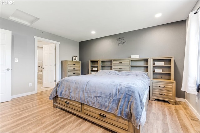 bedroom featuring light hardwood / wood-style floors and ensuite bath