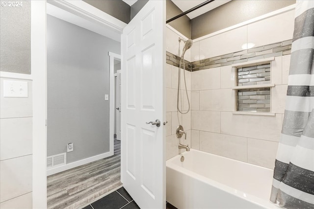 bathroom featuring tile patterned flooring and shower / bathtub combination with curtain