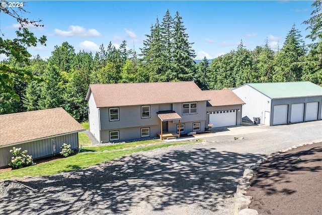 view of front of home with a garage and an outbuilding