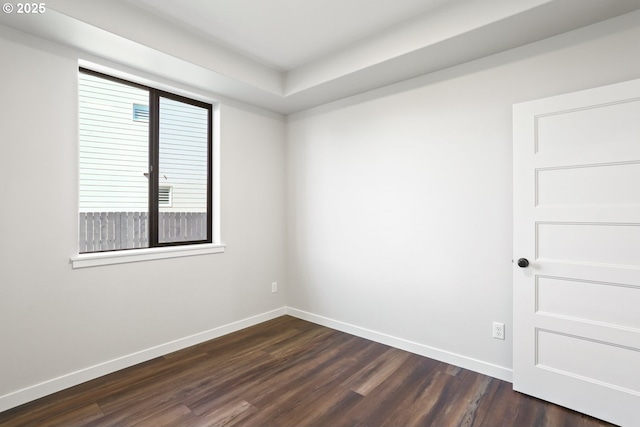 empty room with dark wood finished floors and baseboards