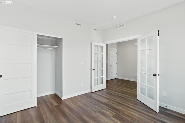 unfurnished bedroom with baseboards, dark wood-style flooring, french doors, and visible vents