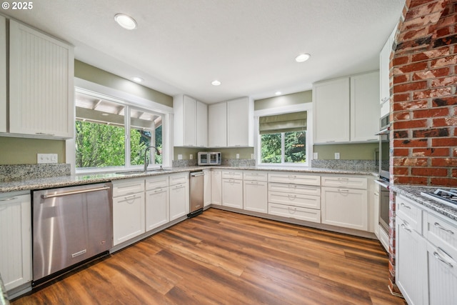 17476 SW Edy Rd, Sherwood, OR 97140 - kitchen featuring stainless steel appliances, dark wood-style flooring, a sink, white cabinetry, and light stone counters