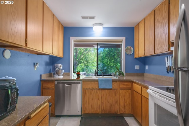 17476 SW Edy Rd, Sherwood, OR 97140 - kitchen with appliances with stainless steel finishes, a sink, dark countertops, and brown cabinets
