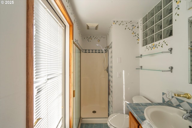 bathroom with vanity, a shower stall, and toilet