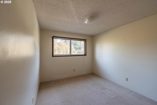 carpeted empty room featuring a textured ceiling