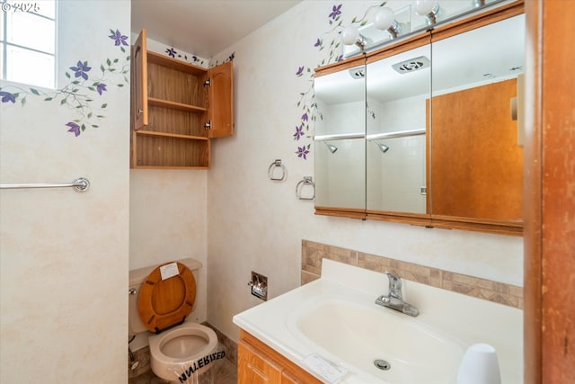 bathroom featuring vanity, toilet, and a stall shower