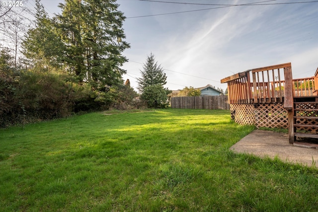 view of yard featuring a wooden deck and fence