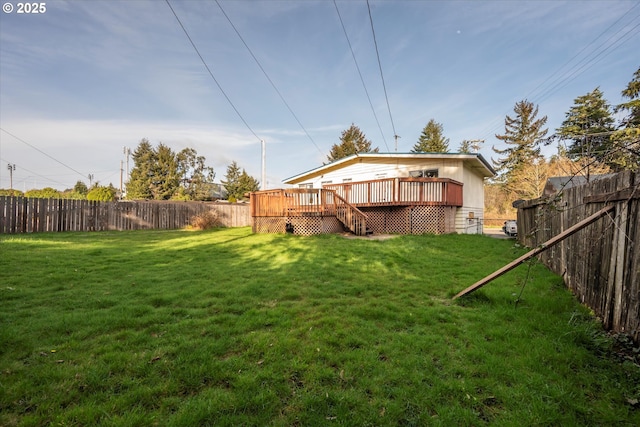 rear view of property featuring a yard, a wooden deck, and a fenced backyard