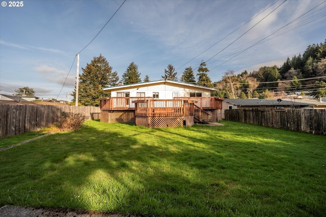 back of property featuring a yard, a wooden deck, and a fenced backyard