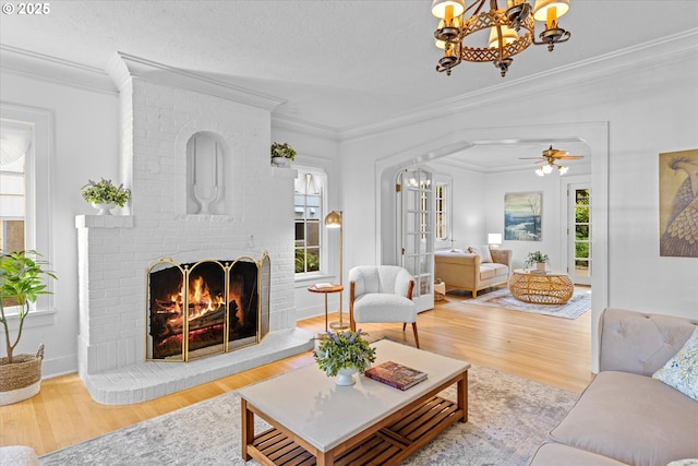 7311 SE 31st Ave, Portland, OR 97202 - living room featuring a chandelier, wood finished floors, a fireplace, and crown molding