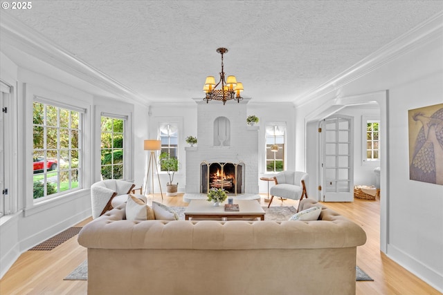 7311 SE 31st Ave, Portland, OR 97202 - living room with light wood-type flooring, a chandelier, ornamental molding, a brick fireplace, and a textured ceiling