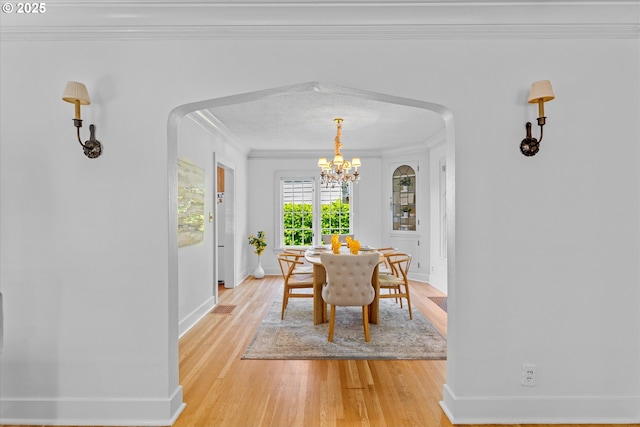7311 SE 31st Ave, Portland, OR 97202 - dining area with arched walkways, ornamental molding, a chandelier, and light wood-type flooring
