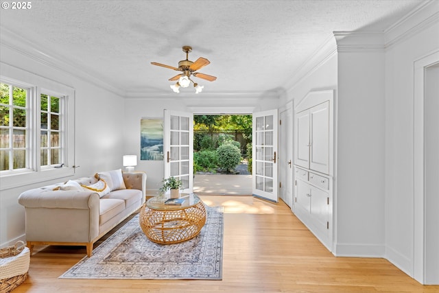 7311 SE 31st Ave, Portland, OR 97202 - living area with healthy amount of natural light, light wood-style flooring, ornamental molding, a ceiling fan, and a textured ceiling