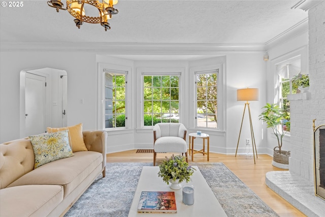 7311 SE 31st Ave, Portland, OR 97202 - living room with light wood finished floors, a chandelier, ornamental molding, a brick fireplace, and a textured ceiling