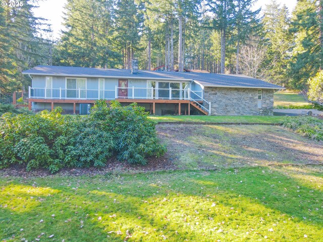 view of front facade with a wooden deck and a front yard