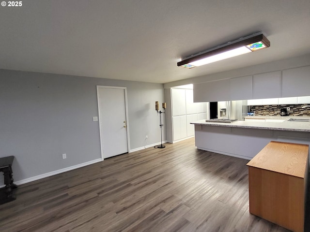 kitchen featuring dark hardwood / wood-style floors, decorative backsplash, and white cabinets