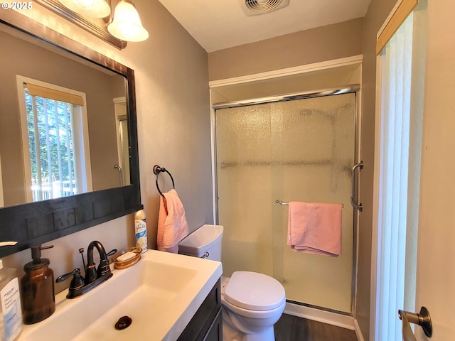 bathroom with vanity, toilet, a shower with door, and wood-type flooring