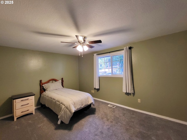 bedroom featuring a textured ceiling, ceiling fan, and dark colored carpet