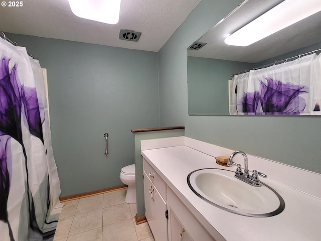 bathroom with vanity, tile patterned flooring, toilet, and a textured ceiling