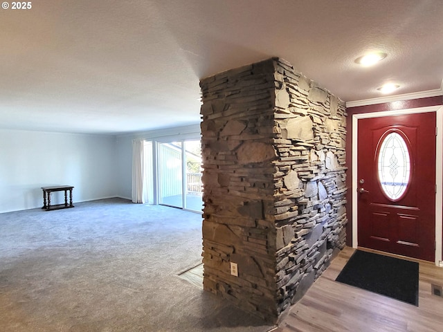 carpeted foyer with crown molding