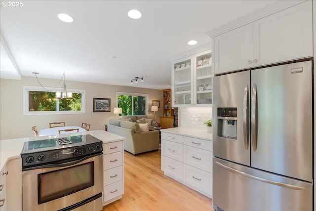 2308 Summit Dr, Lake Oswego, OR 97034 - kitchen featuring stainless steel appliances, light countertops, glass insert cabinets, white cabinetry, and recessed lighting
