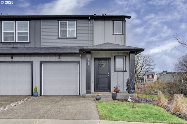 view of front of house with a garage, concrete driveway, board and batten siding, and roof with shingles