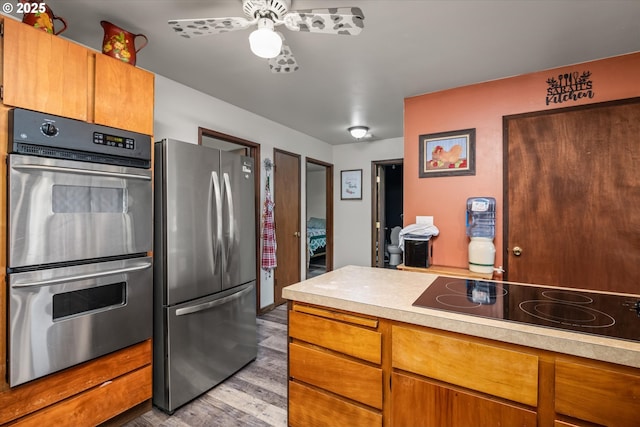 7896 State Highway 38, Drain, OR 97435 - kitchen with stainless steel appliances, light countertops, a ceiling fan, wood finished floors, and brown cabinets