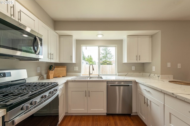 1919 SE 22nd Pl, Renton, WA 98055 - kitchen with appliances with stainless steel finishes, a sink, light stone countertops, and wood finished floors