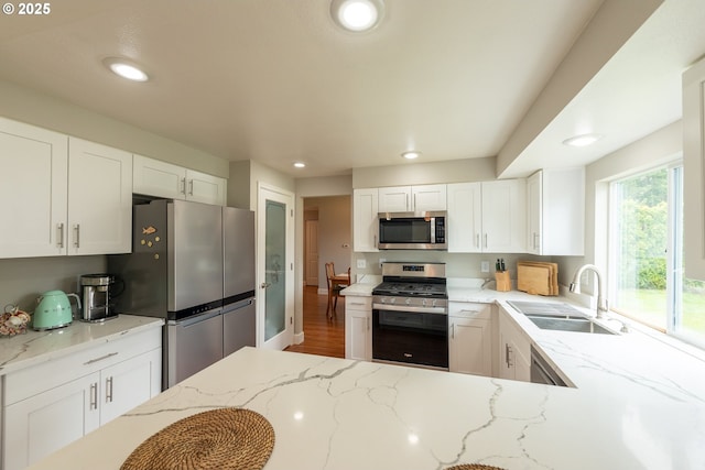1919 SE 22nd Pl, Renton, WA 98055 - kitchen with appliances with stainless steel finishes, a sink, light stone counters, recessed lighting, and white cabinets
