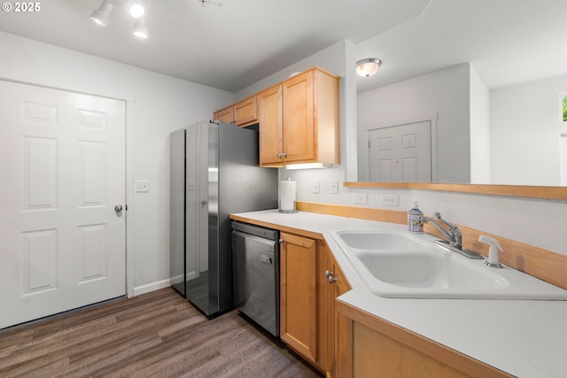 kitchen with a sink, stainless steel appliances, dark wood-style flooring, and light countertops