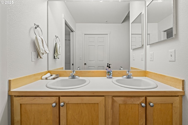 bathroom featuring double vanity and a textured wall