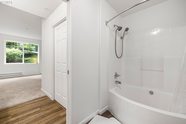 full bath featuring baseboard heating, wood finished floors, tub / shower combination, and baseboards