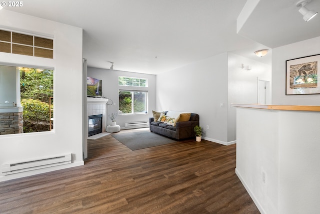 sitting room featuring a baseboard radiator, a fireplace, wood finished floors, and baseboards