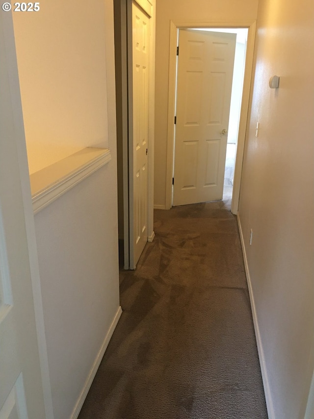 hallway with dark colored carpet