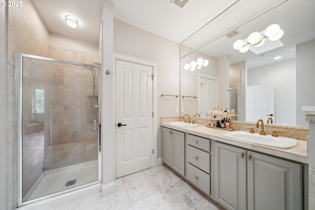 full bath with a sink, a shower stall, and double vanity