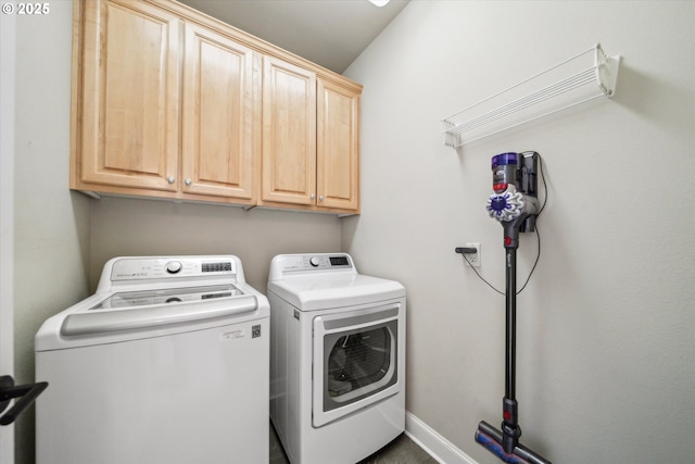 clothes washing area featuring washer and clothes dryer and cabinet space