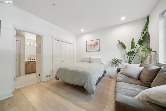 bedroom featuring connected bathroom, light wood-style floors, recessed lighting, visible vents, and a closet